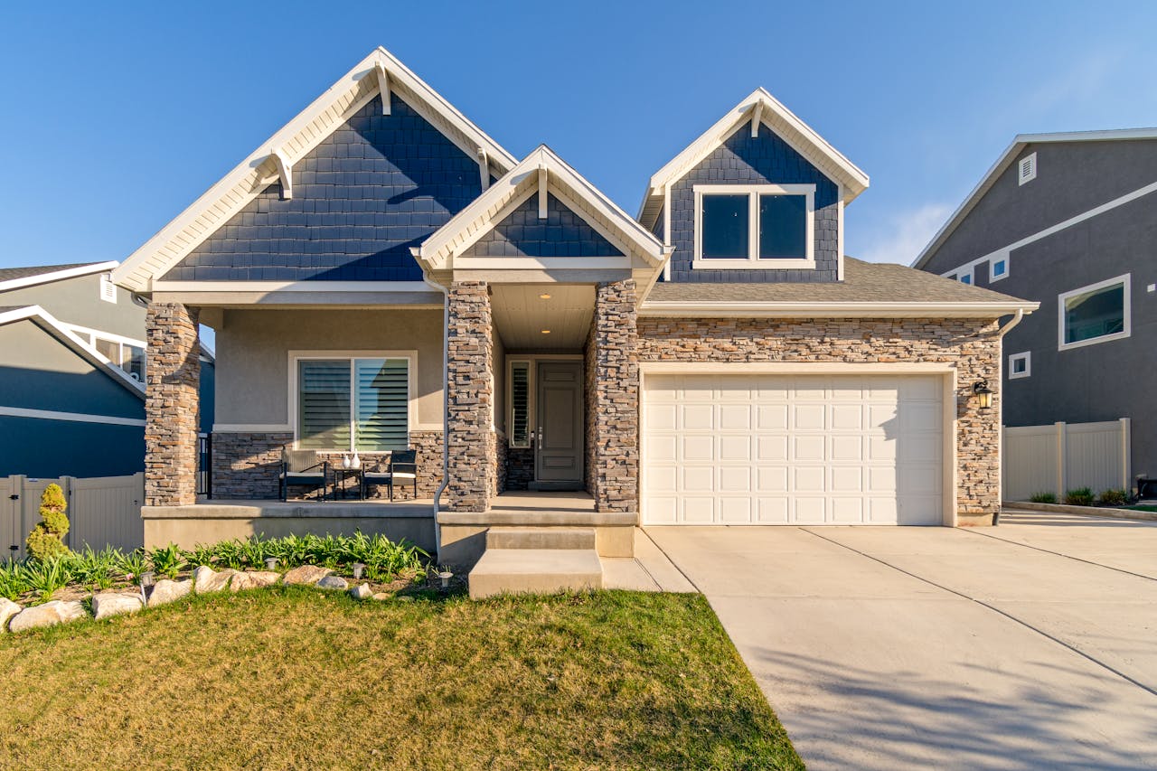 A charming modern suburban home with a stone facade and a neatly maintained lawn.